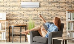 Femme assise dans son fauteuil et qui profite de sa climatisation murale Bielen